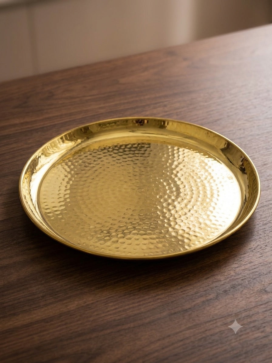 Hammered copper thali plate on wooden surface